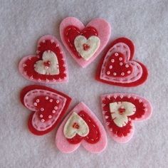 four red and white hearts are arranged in a circle