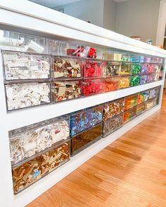 a display case filled with lots of different types of food in plastic bins on the wall