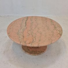 a round marble table sitting on top of a white floor