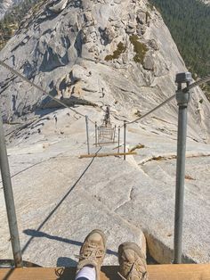 someone's feet on a wooden platform overlooking a mountain