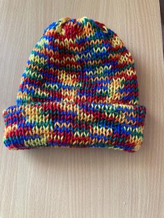 a multicolored hat sitting on top of a wooden table