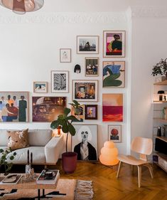 a living room filled with furniture and lots of pictures on the wall above it's coffee table