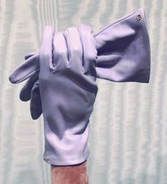 a person's hand with purple gloves on it