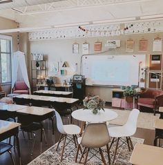 an empty classroom with desks and chairs in front of a white board on the wall