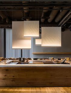 a kitchen with wooden flooring and lights hanging from the ceiling