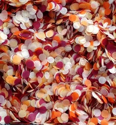 a pile of orange and pink confetti on top of each other