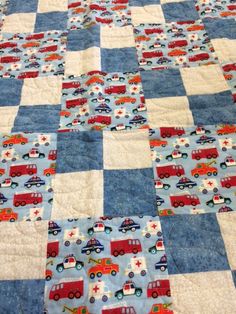 a blue quilt with cars and trucks on it