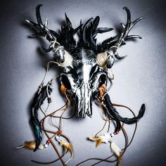 an animal skull with horns and feathers on it