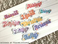 some stickers that are sitting on top of a sheet of paper with words in different colors