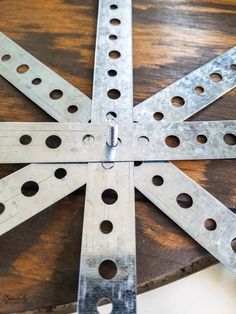 a wooden table topped with metal pieces on top of it's sides and holes in the middle