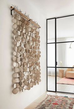 a living room with a large wall hanging made out of plates and other things on the wall