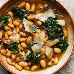 a bowl filled with white beans and spinach