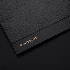 a close up of a black book with gold writing on the front and back cover