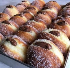 a tray filled with lots of donuts covered in chocolate