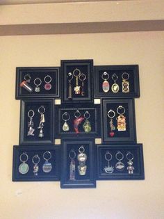 a bunch of framed pictures hanging on the wall with some keychains in them