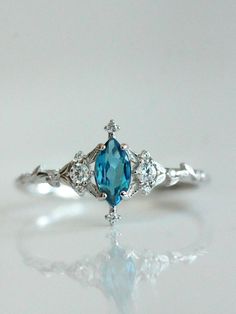 a blue and white diamond ring sitting on top of a table