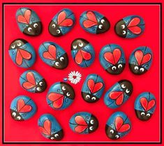 painted rocks are arranged in the shape of hearts with eyes and noses on red background