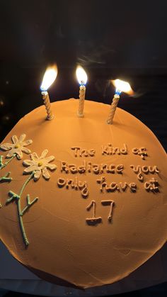 a birthday cake with three lit candles on it