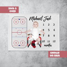 a baby sitting on top of a chair in front of a hockey rink calendar with the name michael jack