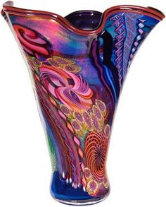 a colorful glass vase sitting on top of a table