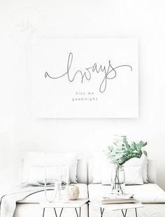 a living room with white furniture and a painting on the wall above it that says always