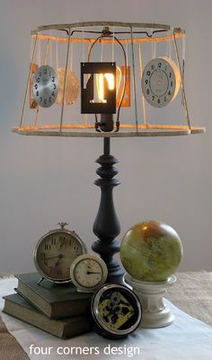 a lamp that is sitting on top of a table next to some books and clocks