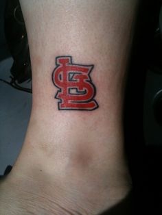 a foot with a tattoo on it that has the st louis baseball team's logo