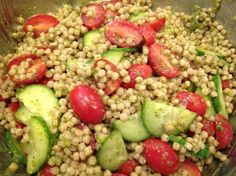 a salad with cucumbers and tomatoes in a glass bowl