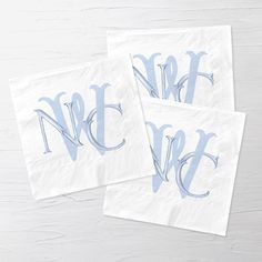 two napkins with the letter n and w in blue ink on white paper, sitting next to each other