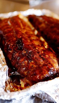 two pieces of meat sitting on top of tin foil