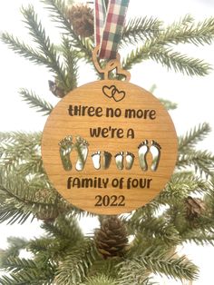 a wooden ornament hanging from a christmas tree with footprints and hearts on it