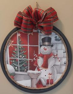 a snowman is hanging on the wall next to a window