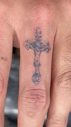 a hand with a cross tattoo on it