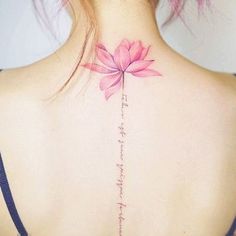 the back of a woman's neck with a pink flower on it