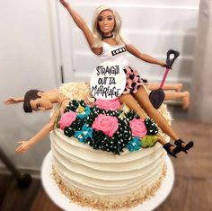 a barbie doll sitting on top of a cake