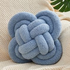 a blue knot pillow sitting on top of a white couch