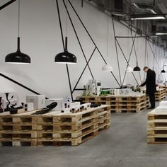 a man is standing in the middle of a room with lots of wooden pallets