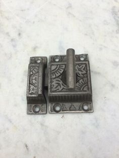 two antique cast iron door latches with decorative designs