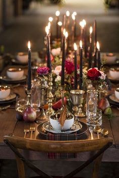 a table set with candles, plates and glasses