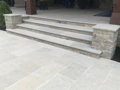 an outdoor patio with stone steps and pillars