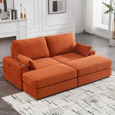 an orange couch sitting on top of a white rug