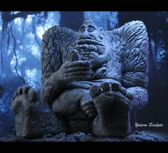 a statue of a creature sitting in the middle of a forest with its legs spread out