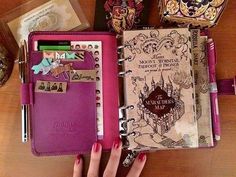 there is a notebook with many things in it on the table next to a hand