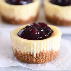 mini cheesecakes with blueberry sauce on top sitting on wax paper and ready to be eaten