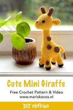 a crocheted giraffe next to a potted plant on a window sill