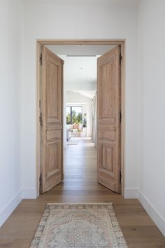 an open door leading to a living room with a rug on the floor in front of it