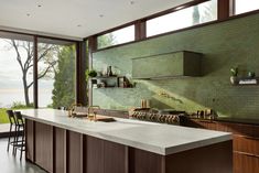 a kitchen with an island counter and large windows