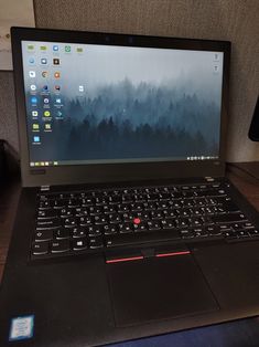 an open laptop computer sitting on top of a wooden table