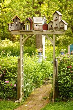 an image of a garden arbor with birdhouses on it's top and the bottom