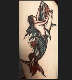 a woman with a fish tattoo on her arm and chest is holding a fish in her hand